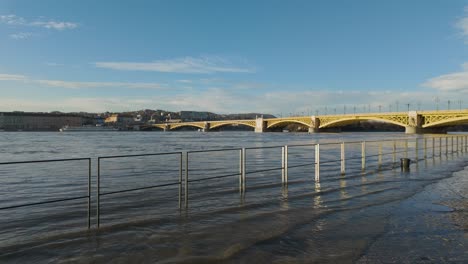 Wide-shot-of-the-flooding-Danube-River-and-Margaret-Bridge-in-the-Background-at-Budapest,-Hungary---December-2023