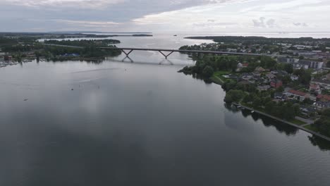 Huge-bridge-bro-connects-the-city-Motala-in-Sweden,-aerial-pan-right,-cloudy-day