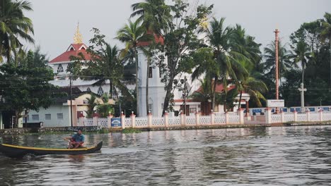 Traditional-Alleppey-curch-behind-palm-trees,-riverside-view,-Kerala-Backwaters,-India
