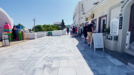 Oia-Santorini-Greece-Island-Travel-Tourist-Immersive-Walk,-Europe,-4K-|-Greek,-Aegean,-Sea,-Cliffside,-Ocean,-City,-Vacation,-Shopping,-White,-Marble,-Crowd,-Flowers,-Traveler,-People,-Summer,-Fence