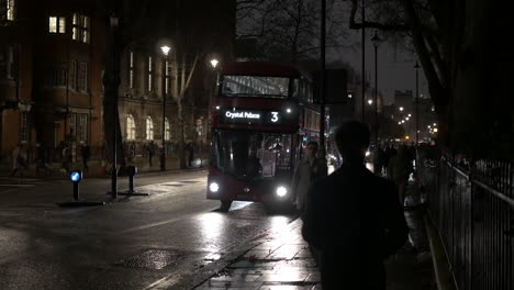 Busy-London-street-at-night-with-cyclists-double-decker-bus-and-people-walking