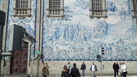 Nach-Oben-Neigende-Aufnahme,-Menschen,-Die-Um-Den-Stadtplatz-Herumlaufen,-Malerischer-Blick-Auf-Die-Außengestaltung-Unserer-Marienkirche-In-Porto,-Portugal