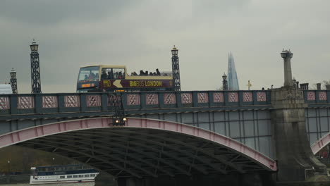 London-double-decker-tour-bus-crosses-bridge-in-front-of-the-Shard