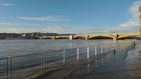 Tilt-Locked-Pedestal-shot-of-the-Flooded-Quay-of-Pest-and-Margaret-Bridge-in-Budapest,-Hungary-during-the-flood-of-River-Danube---December-26,-2023