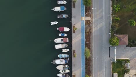 Aerial-top-down-view-of-parked-boats-on-Fethiye-City-coast-next-to-street-and-cycleway,-Turkeyv