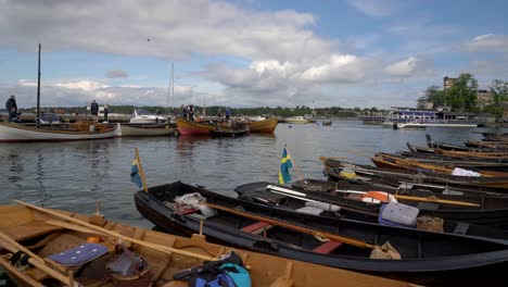 Vintage-boats-moored-in-Västervik-marina-in-Sweden,-flying-the-swedish-flag