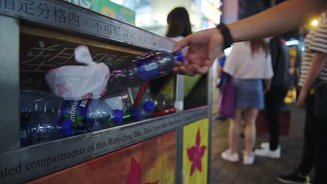 Man-Put-An-Empty-Plastic-Bottle-On-The-Colorful-Litter-Bins-For-Different-Kinds-Of-Garbage-In-The-City-Center-Of-Hong-Kong