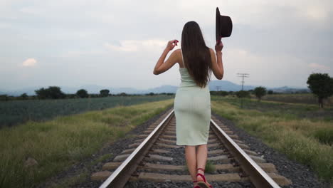 Confident-model,-walking-smoothly-on-a-train-track-at-dusk---Tracking-shot