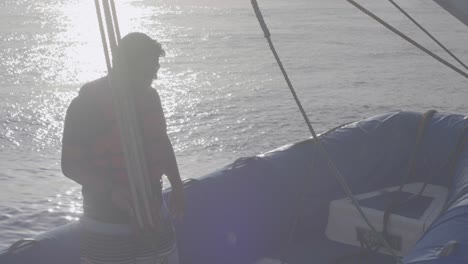 Un-Hombre-Está-Parado-En-Un-Barco-Azul-Que-Cuelga-De-Unas-Cuerdas-De-Un-Crucero-Por-El-Océano-De-Las-Islas-Galápagos