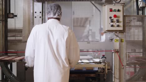 Rückansicht-Eines-Fabrikarbeiters,-Der-Große-Tabletts-In-Einer-Französischen-Brotfabrik-überprüft