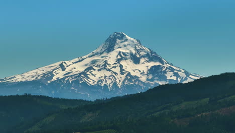 Snowy-Mount-Hood-mountain-peak,-sunny-summer-in-Oregon,-USA---Zoomed-drone-shot