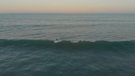 Beginner-surfer-struggling-to-float-and-cruise-on-the-mild-waves-of-beach-Santinho-at-golden-hour