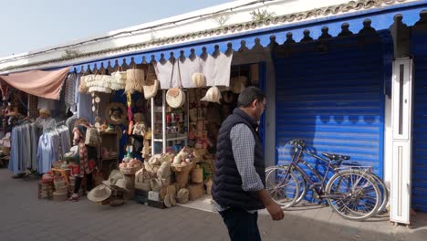 Store-facade-with-people-passing-by-in-Essaouira-bazaar,-Medina