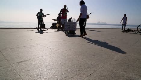 Saxophone-player-playing-with-a-street-band-at-Praca-Maua,-at-sunset,-in-the-center-of-Rio-de-Janeiro,-Brazil