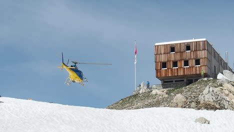 Zeitlupe-Eines-Rettungshubschraubers,-Der-Vom-Schneebedeckten-Hügel-In-Den-Schweizer-Alpen-Abhebt