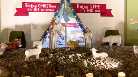 Life-size-Mary,-Joseph,-angels,-and-Shepherd-looking-over-Jesus-in-awe-at-Bronner's-Nativity-Scene-in-Frankenmuth,-Michigan