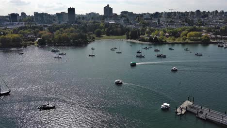 Drone-shot-of-False-Creek-in-the-summer-in-downtown-Vancouver-with-boats,-trees-and-buildings-in-the-shot