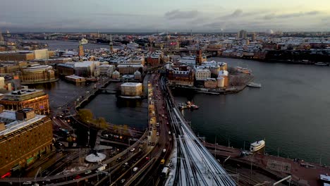 Sunset-drone-footage-of-the-traffic-in-Stockholm,-Sweden-while-approaching-the-Gamla-Stan,-Old-Town