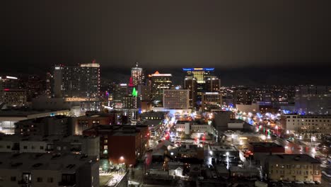 Salt-Lake-City,-Utah-skyline-at-nighttime---aerial-push-in-flyover-in-December