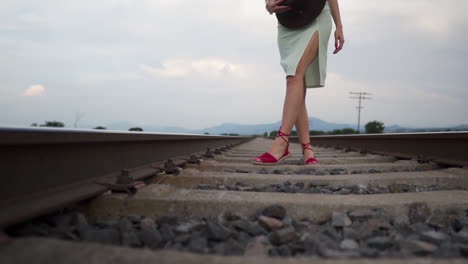 Frau-In-Sommerkleid-Und-Roten-Sandalen-Modelliert-Sinnlich-Auf-Bahngleisen-–-Kranaufnahme-Aus-Niedrigem-Winkel