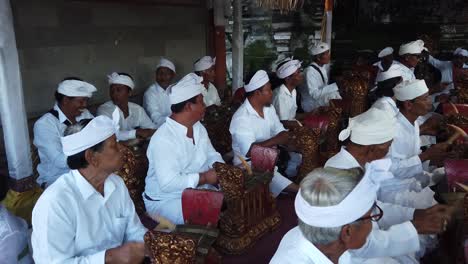 Gamelan-Angklung-Musicians-Play-Rhythmic-Complex-Music,-Balinese-Hindu-Ceremony-Temple-Atmosphere-dressed-with-White-Outfits