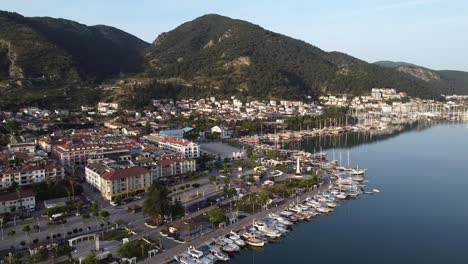 Stunning-aerial-view-of-Fethiye-City-with-parked-boats-in-Mediterranean-coast-and-mountains-in-background,-Turkey