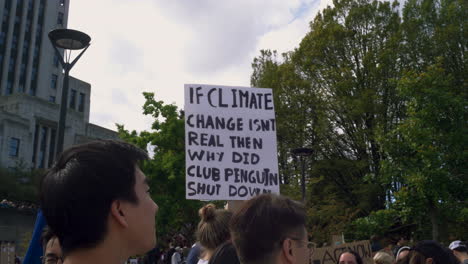 Ein-Klimaschutz-Demonstrant-Hält-Ein-Schild-Mit-Einem-Cleveren-Slogan,-Im-Hintergrund-Das-Rathaus-Von-Vancouver