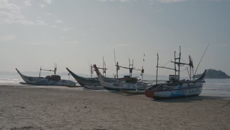 Traditional-Fishing-Boats-On-A-Sandy-Beach-In-Weligama,-Matara,-Sri-Lanka