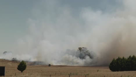 Grass-fire-on-hot-windy-day-in-Victoria,-huge-wall-of-smoke-racing-across-farmland