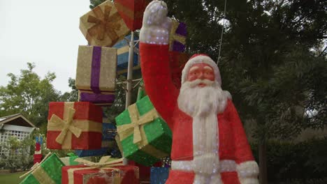 Weihnachtsmann-Statue-Steht-Vor-Einem-Stapel-Geschenke-Bei-Der-„Weihnachtslichter-Spektakel“-Lichtshow-In-Den-Hunter-Valley-Gardens,-New-South-Wales,-Australien