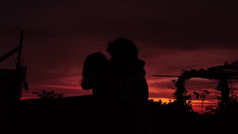 Silhouette-Eines-Romantischen-Paares,-Das-Nach-Sonnenuntergang-Tanzt,-Sich-Umarmt-Und-Sich-Liebevoll-Küsst