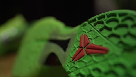 Grüne-Nike-Kobe-6-Protro-Grinch-2020-Schuhsohle,-Gefilmt-Auf-Einem-Braunen-Tisch-Mit-Dunklem-Hintergrund