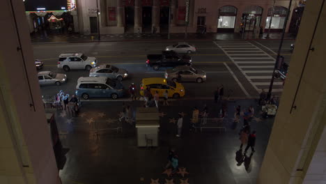 Cinematic-top-view-of-busy-Hollywood-Blvd-at-night-as-tourists-pass-by