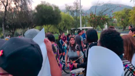 A-woman-is-riding-a-bike-and-several-others-are-playing-drums-during-a-protest-march-agains-violence-and-abuse-from-men-towards-women