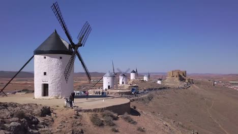 Drone-Shot,-Truck-right-quick-movement-through-line-of-Windmills-in-Consuegra