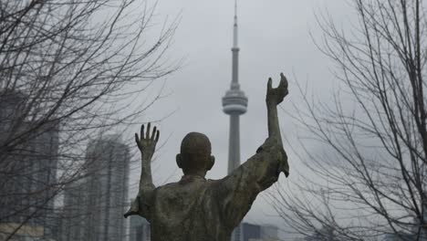 Statue-At-Ireland-Park,-Downtown-Toronto-Skyline-In-Background
