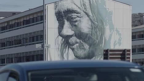 Abgesperrte-Sicht-Auf-Die-Wandkunst-Des-Künstlers-Guido-Van-Helten-An-Der-Seite-Des-Gebäudes-Mit-Vorbeifahrendem-Verkehr-In-Nuuk