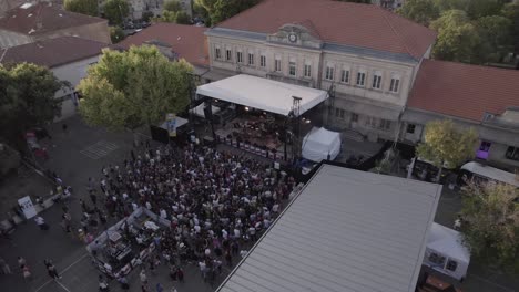Aerial-view-over-small-festival-in-with-people-gathering-for-the-live-music-in-southern-France