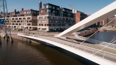 Aerial-view-buildings-in-Kalasatama-district-passing-the-Isoisansilta-bridge,-on-a-sunny-day,-in-Helsinki,-Uusimaa,-Finland---Dolly,-drone-shot