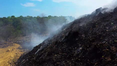 Luftaufnahme,-Drohnenschuss-über-Feuerwehrleuten,-Die-An-Einem-Sonnigen-Tag-In-Der-Dominikanischen-Republik-Einen-Waldbrand-Löschen-Und-Rauch-Aufsteigen
