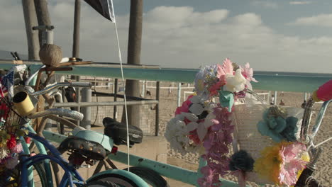 Cinematic-Slow-Motion-shot-of-interesting-bicycles-covered-in-decorations,-flowers-and-flags-at-the-beach-in-Manhattan-Beach,-California