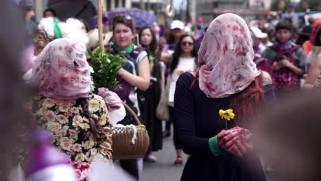 Dos-Mujeres-Con-El-Rostro-Cubierto-Y-Sosteniendo-Trapos-Con-Sangre-En-Una-Protesta-Que-Pide-La-Legalización-Del-Aborto-En-Ecuador