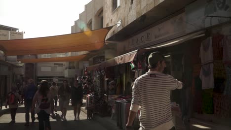 People-walking-down-busy-market-street-in-ancient-town-Madaba,-Jordan