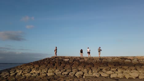 Tourists-Take-Pictures-at-Bali-Beach-Dock-Panoramic-Landscape-of-Sanur-Indonesia