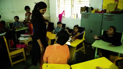 The-camera-pans-forward-showing-an-entire-class-room-at-a-mental-disorders-NGO-School-where-a-child-is-lovingly-cradled-by-the-teacher,-Right-to-Education