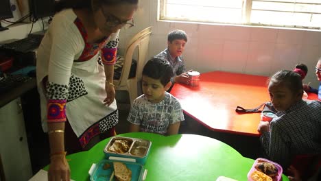 In-an-NGO-school,-young-children-open-their-tiffin-and-have-breakfast-during-lunch-break,-Right-to-Education