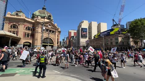 Protesters-marching-past-Flinders-Station-Melbourne-Australia-stopping-all-traffic,-protesting-against-Dan-Andrews