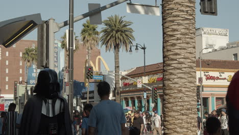 Costumed-street-performers-dressed-as-comic-book-superhero-Spiderman-and-Star-Wars-villian-Darth-Vader-greet-and-taking-photos-with-tourists-in-Hollywood-on-the-historic-Walk-of-Fame-in-Los-Angeles
