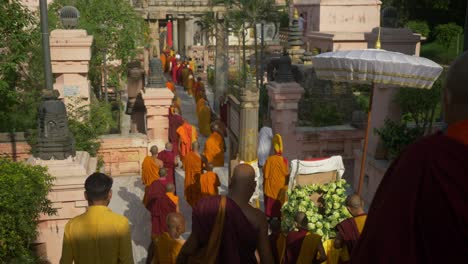 Monks-walking-down-the-temple-to-celebrate-the-Holy-Dalai-Lama's-88th-birthday-at-the-sacred-Mahabodhi-Temple-Complex,-Wide-Shot