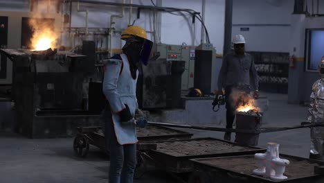 investment-casting-foundry-the-finished-casting-is-being-filled-into-the-mold-and-both-operators-are-fire-protected-dressed